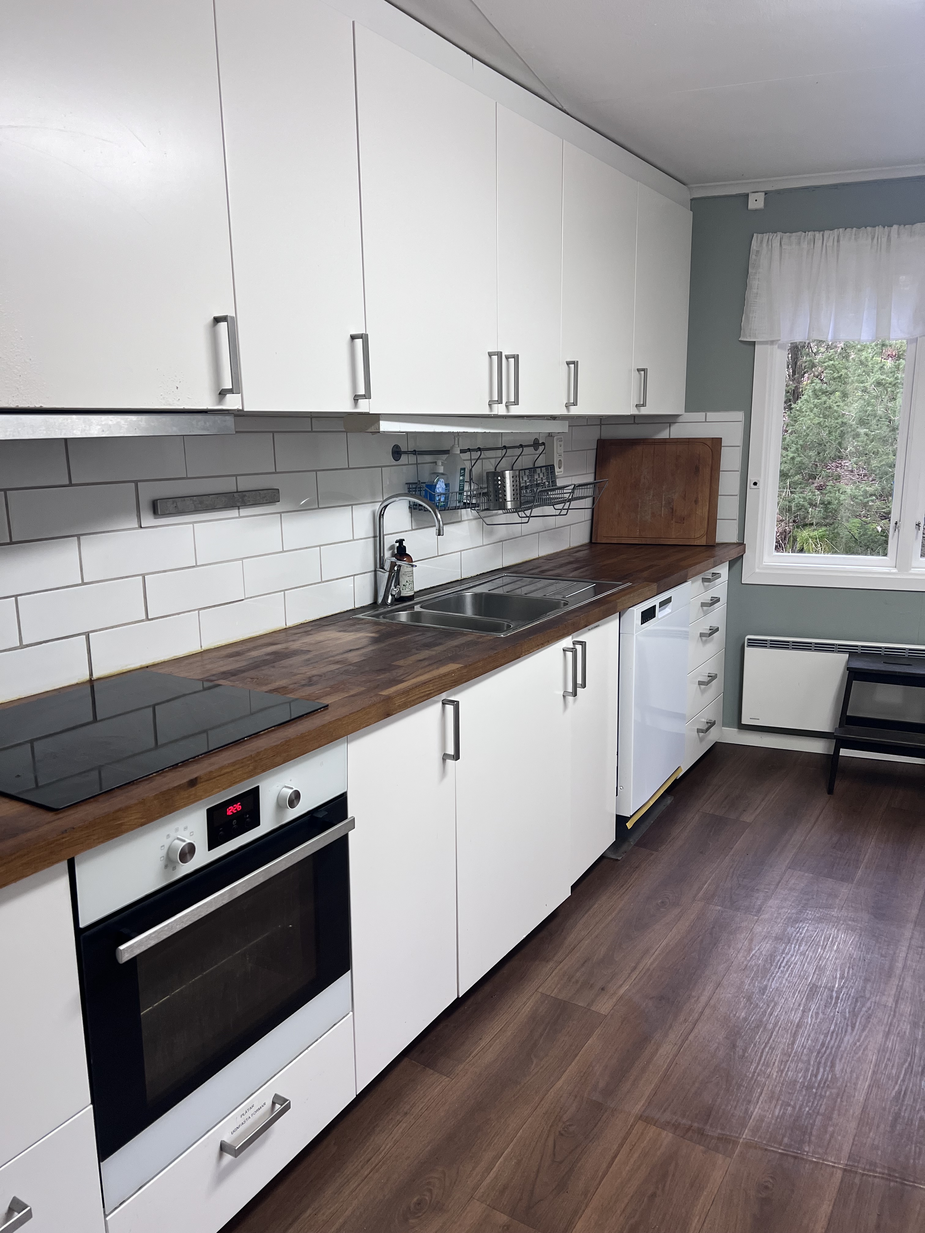 Rymligt och modernt kök i Flatenstugan sommarläger, utrustat med rostfria vitvaror, stora träarbetsytor och säkerhetsfunktioner anpassade för barns matlagningsaktiviteter.